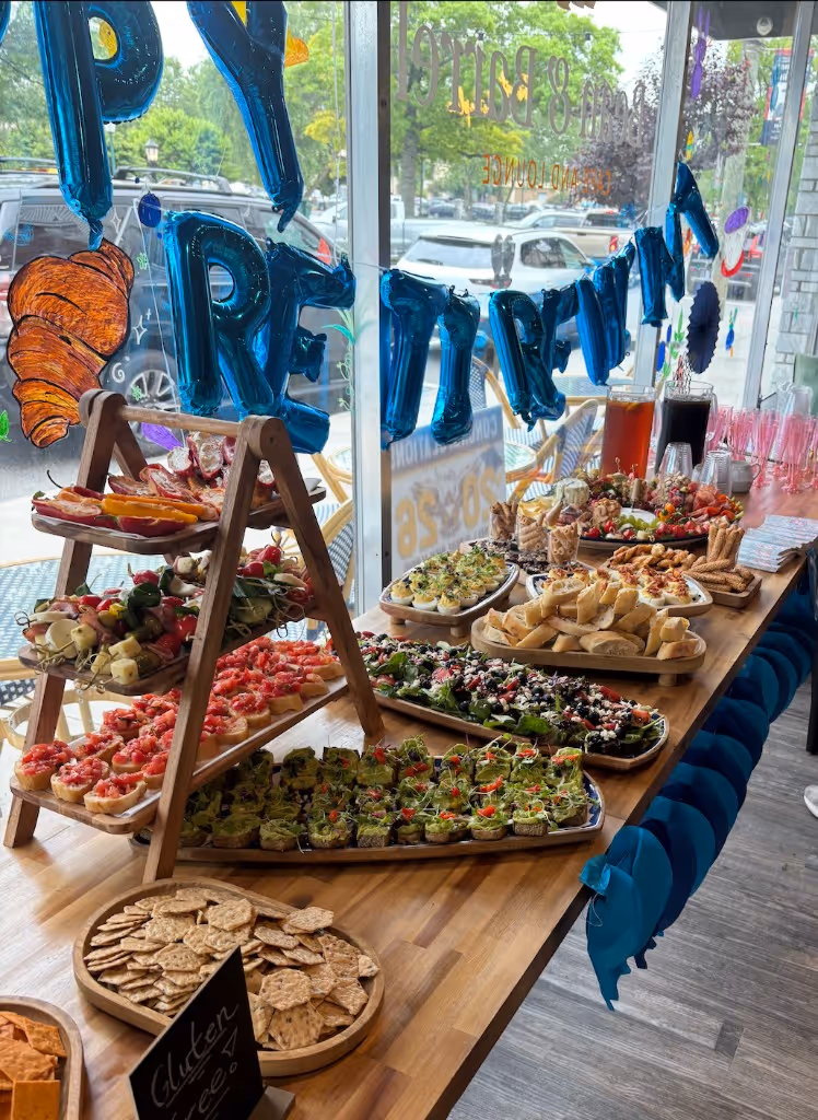 Catering spread by the front window with appetizers, salads, and deviled eggs at Bean and Barrel